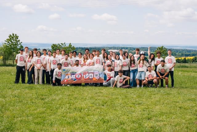 Grupul Job Jam în tricouri la fel, cu bannerul proiectului, pe un deal din Cehia